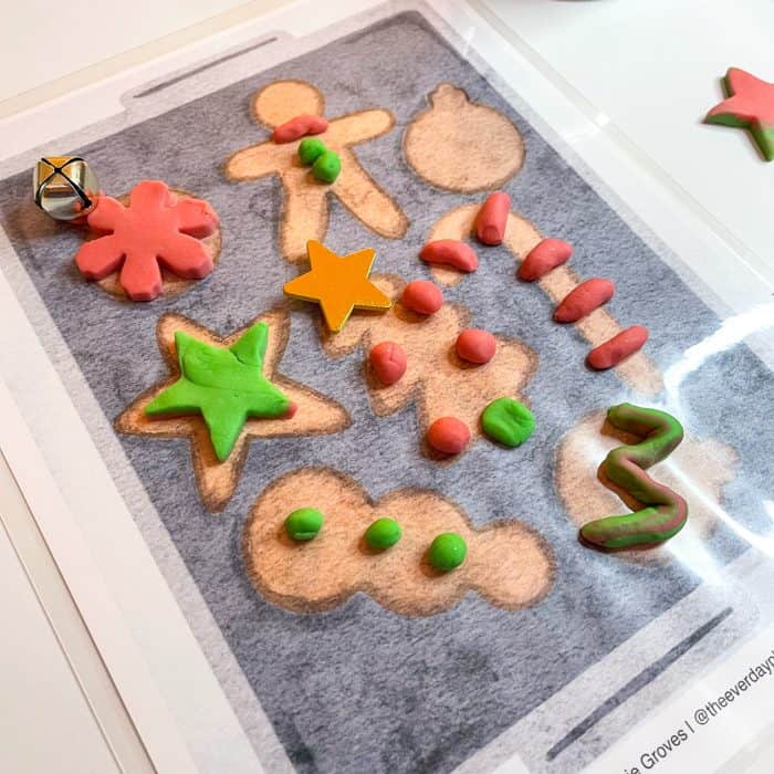 Red and Green Playdough on a Playdough mat of Christmas cookies