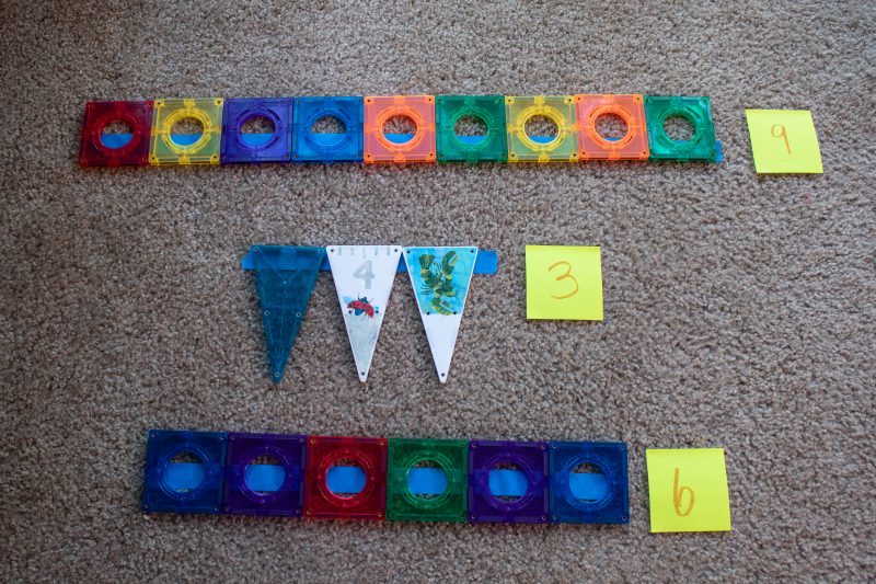 Painters tape on carpet with magnetic tiles measuring how many long the tape is.