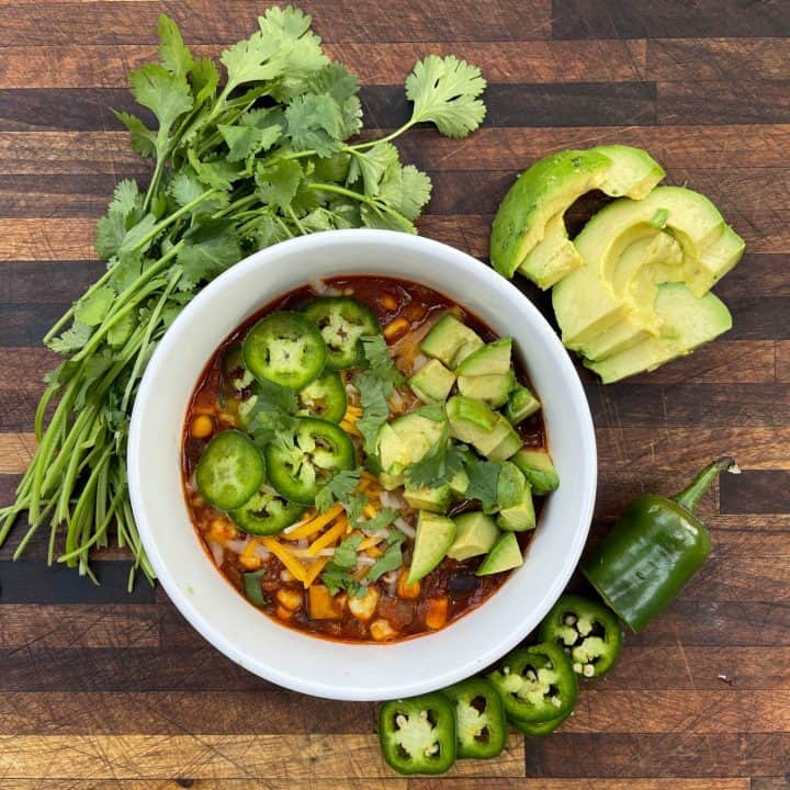 Slow Cooker Chili topped with cheese, avocado, and jalapeños