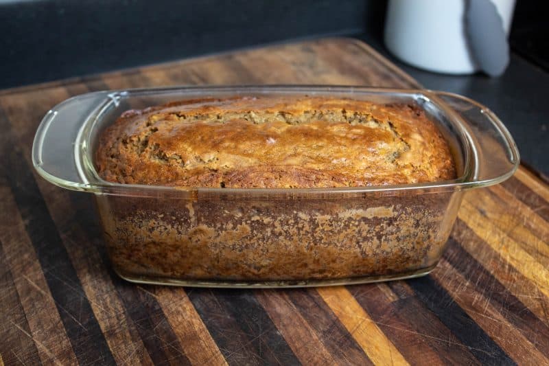 Sourdough Banana Bread loaf in ban sitting a cutting board. 