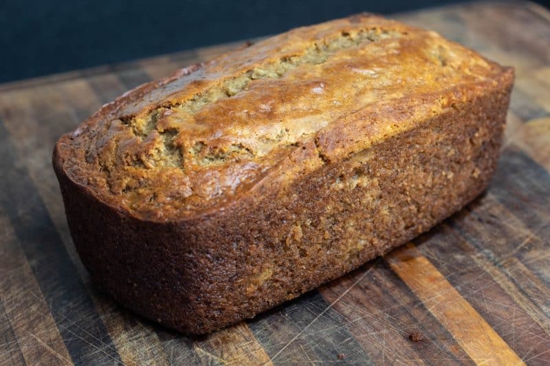 Sourdough Banana Bread loaf sitting a cutting board. 