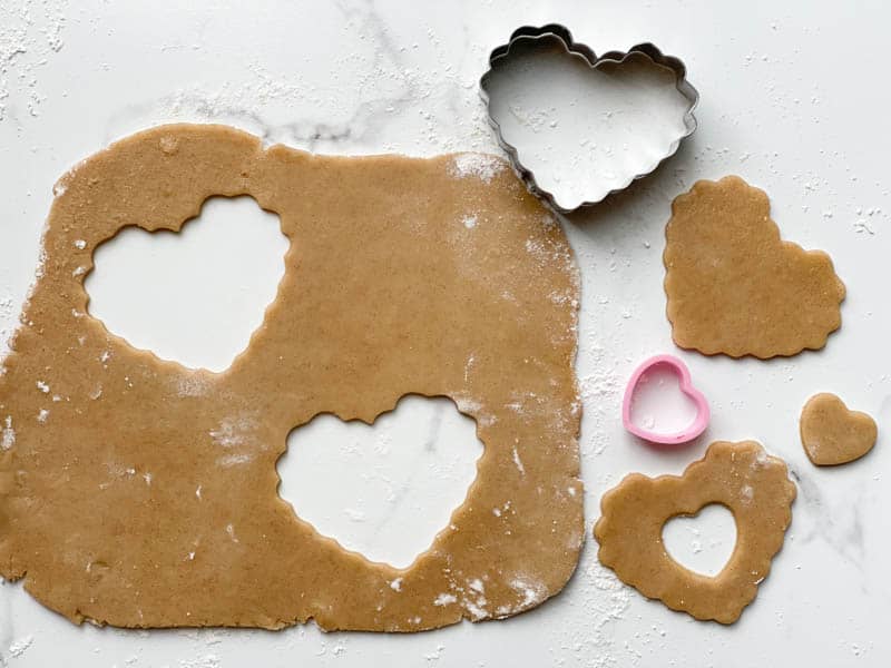 Strawberry Jam Cookie dough rolled out with heart-shaped cookie cutters